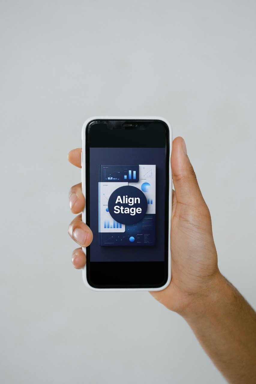 Hand holding a smartphone with an app interface on a plain background