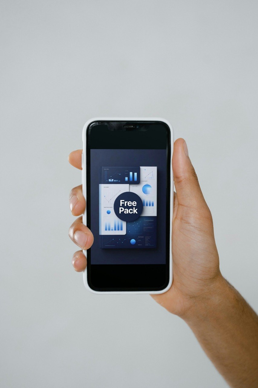 Hand holding a smartphone with a screen displaying a free pack offer on a gray background