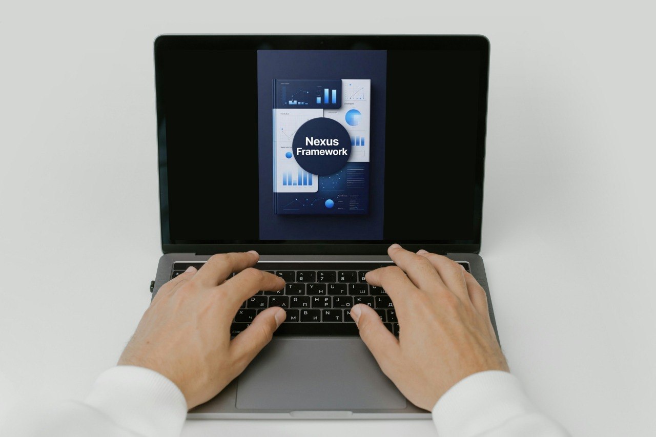 Person using a laptop with 'Nexus Framework' displayed on the screen