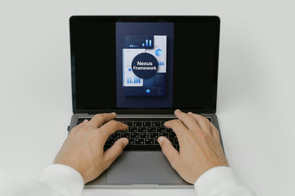 Person using a laptop with 'Nexus Framework' displayed on the screen
