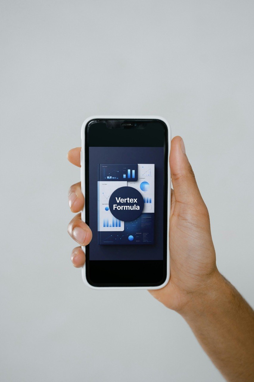 Hand holding a smartphone displaying a 'Vertex Formula' app on a light gray background